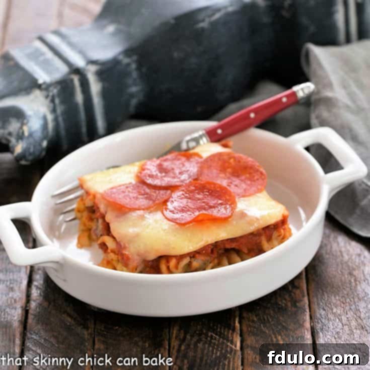 slice of pizza casserole in a small white casserole dish