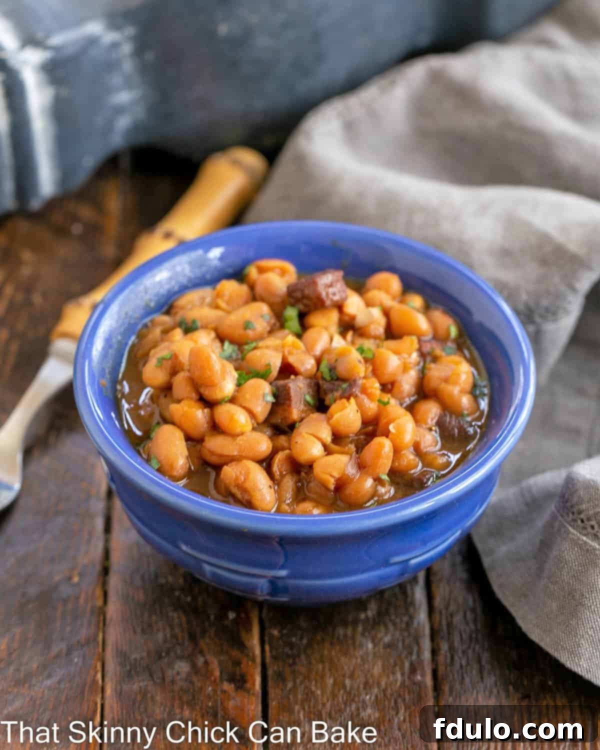 Grandma's Classic Baked Beans 4 Blue ceramic bowl filled with homemade baked beans.