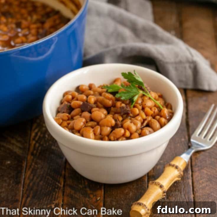 Grandma's Classic Baked Beans 5 small white bowl filled with baked beans in front of a blue Dutch oven filled with beans