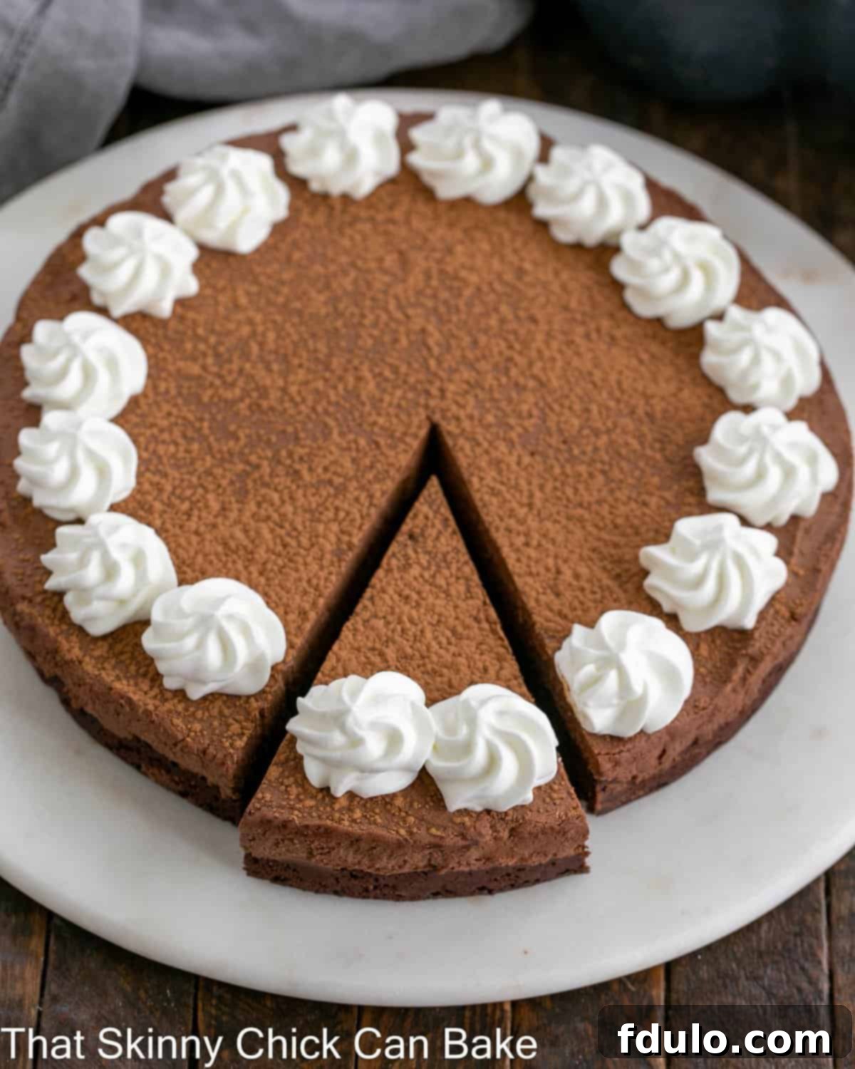 A generous slice of Whipped Ganache Chocolate Cake, revealing its dense cake base and airy ganache topping, ready to be enjoyed.