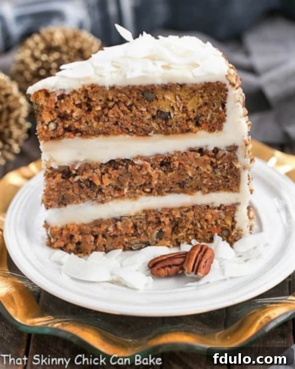 A perfectly sliced piece of three-layered Caramel Filled Carrot Cake, showcasing the rich caramel filling and smooth cream cheese frosting, presented on a pristine white dessert plate.