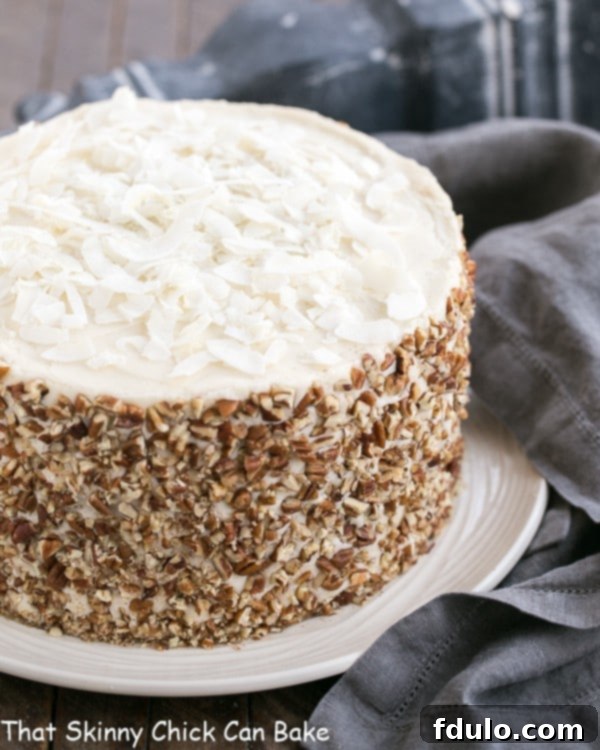 A stunning, whole Caramel Filled Carrot Cake adorned with cream cheese frosting, elegantly placed on a white serving plate, ready to be enjoyed.