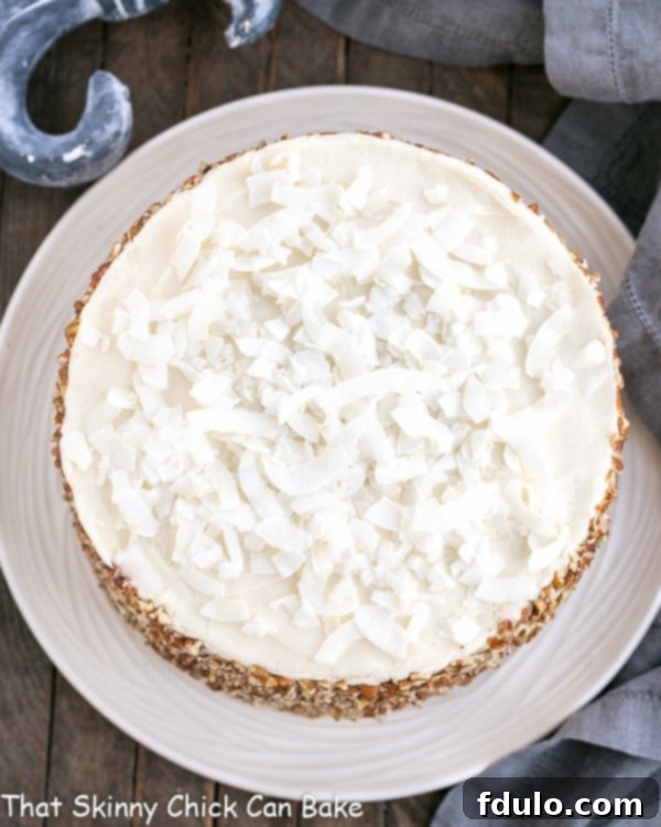 An overhead view of a slice of Caramel Filled Carrot Cake on a white plate, highlighting the dense cake, caramel layers, and fluffy cream cheese frosting.