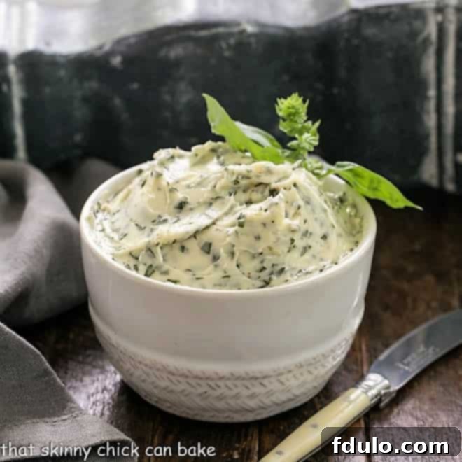 Close-up side view of a grilled corn on the cob, generously spread with vibrant green basil butter, resting on a rustic wooden platter with an ivory handled knife.