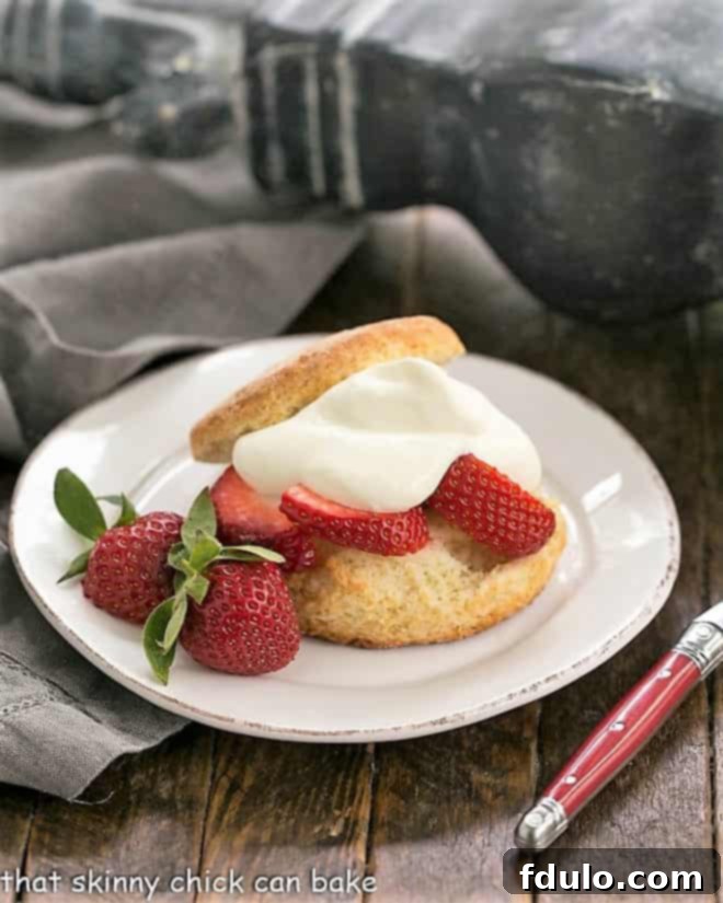 Strawberry Shortcakes with White Chocolate Whipped Cream on a white plate, ready to be enjoyed.