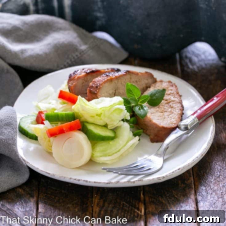 Tenderloin slices on a white plate with salad
