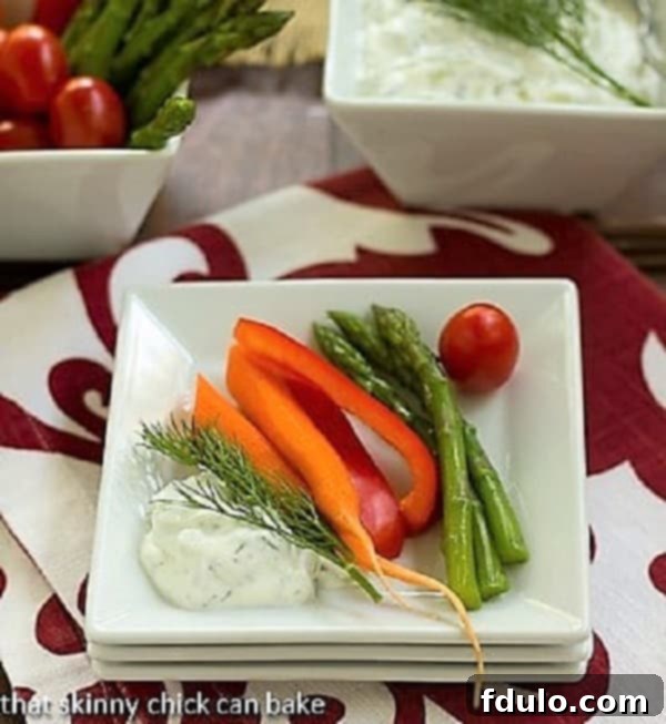 Tzatziki on a stack of white plates with fresh vegetables