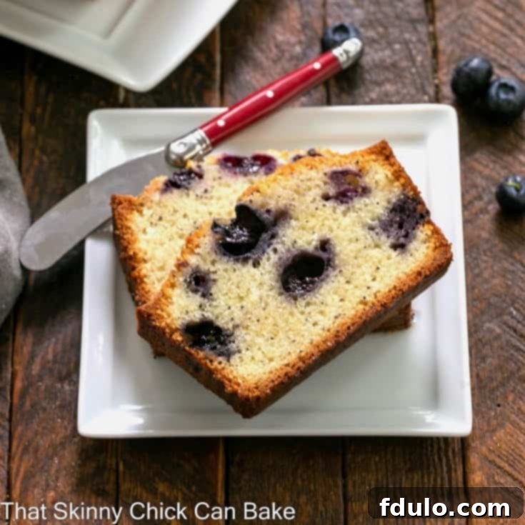 Blueberry Poppy Seed Bread slices on a square white plate with a red handled knife.