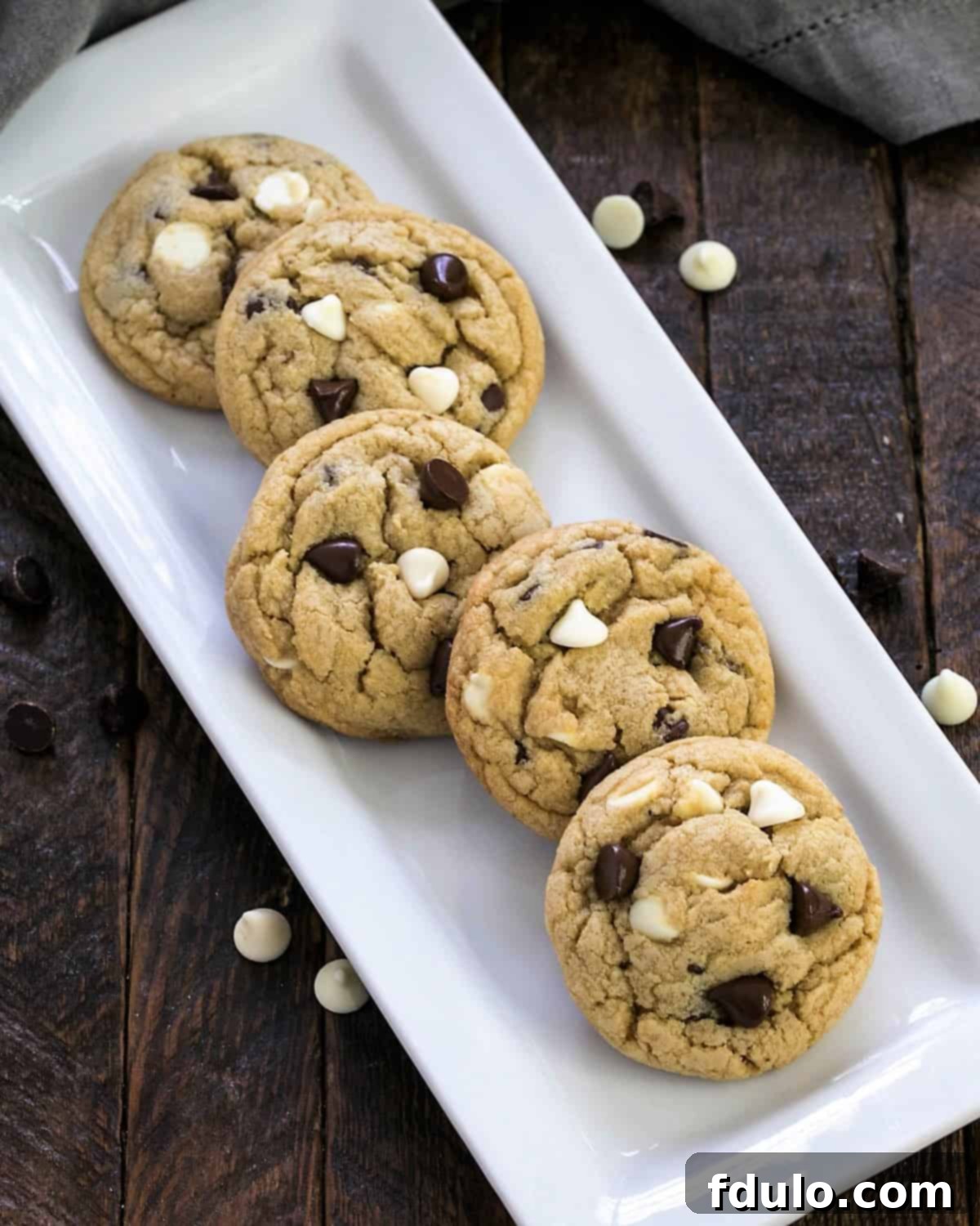 Overhead view of soft chocolate chip cookies on a white tray, showcasing their perfect golden-brown edges and melted chocolate chips.