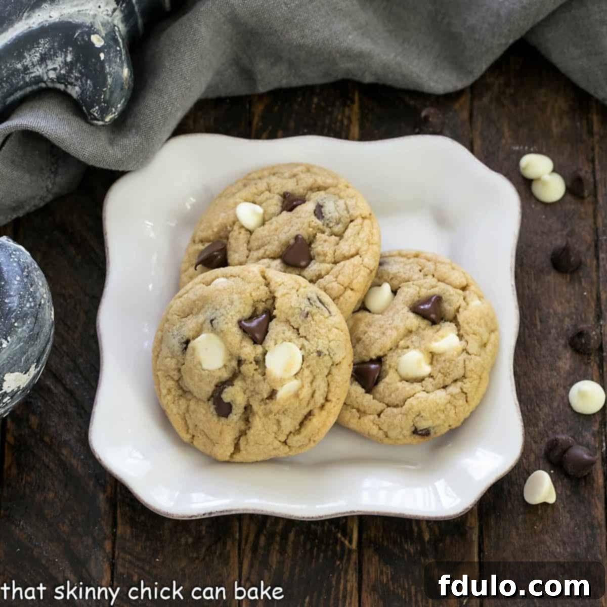 Overhead view of three soft chocolate chip pudding cookies elegantly presented on a square dessert plate, inviting a delicious bite.