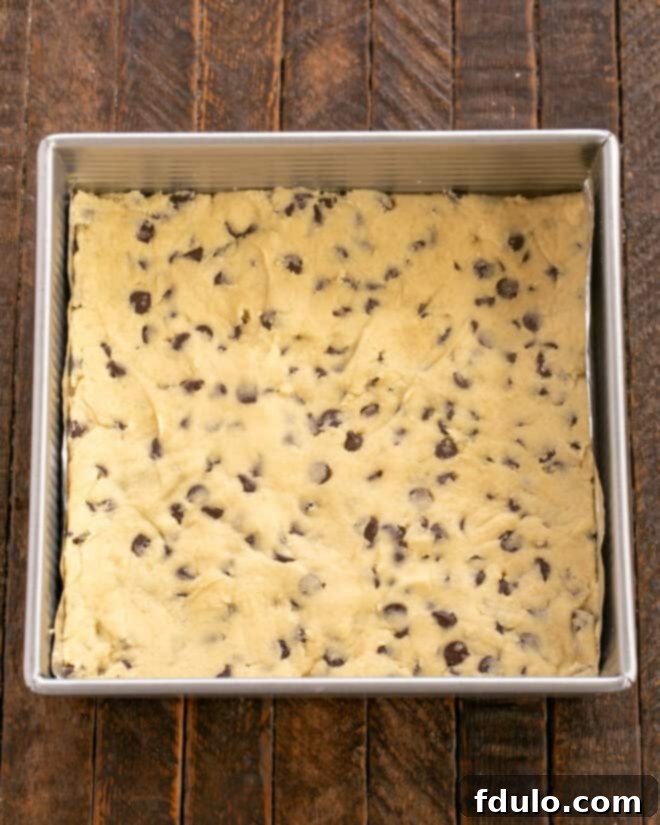 Chocolate Chip Oreo Brownies 9 The prepared cookie dough is spread evenly into the bottom of a baking pan.