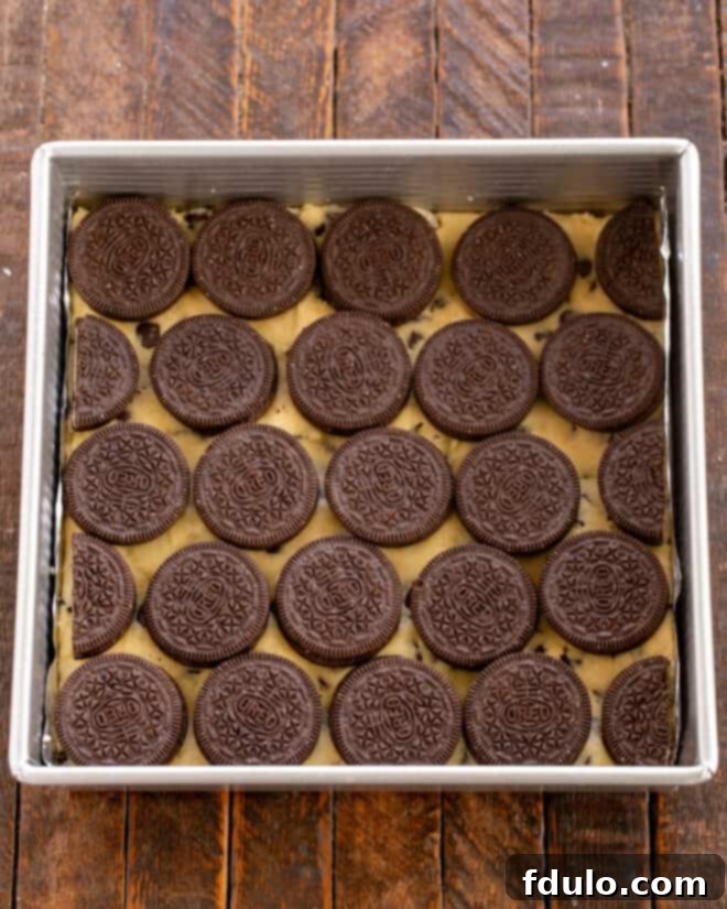 Chocolate Chip Oreo Brownies 10 The cookie dough layer is topped with whole Oreo cookies, arranged neatly.