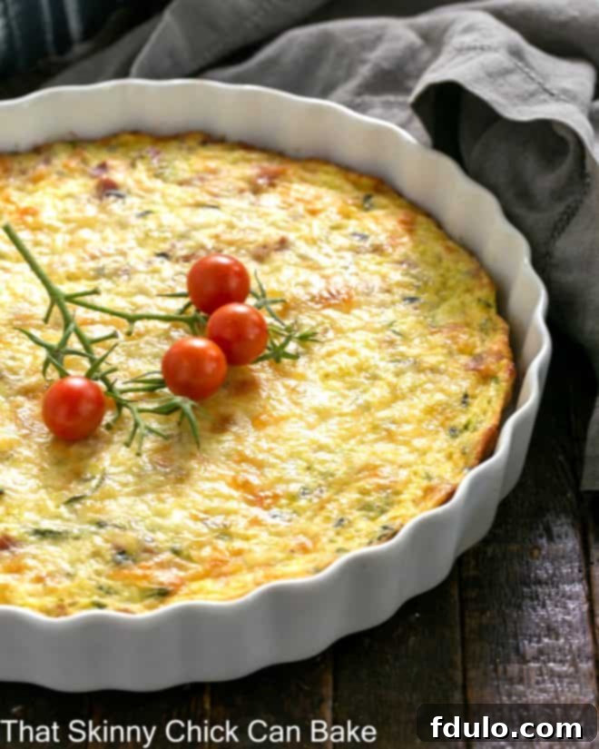Savory Zucchini and Prosciutto Quiche 3 Quiche in a shallow white souffle dish with cherry tomato garnish.