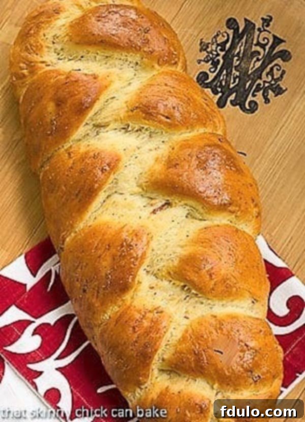 Overhead view of a beautifully braided Parmesan Prosciutto Loaf, sliced to reveal the savory fillings within.