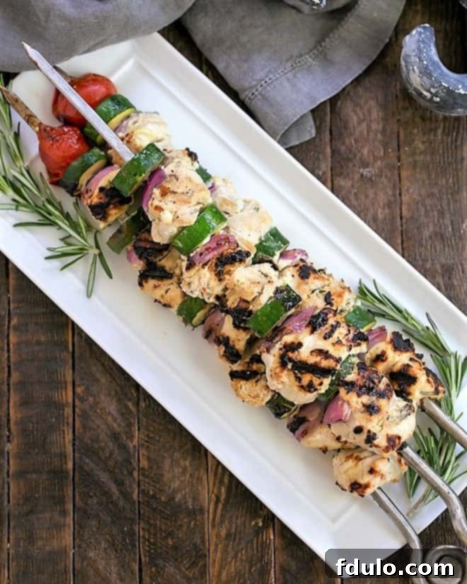 Overhead view of a white platter featuring expertly grilled chicken kabobs, ready to be served and enjoyed.