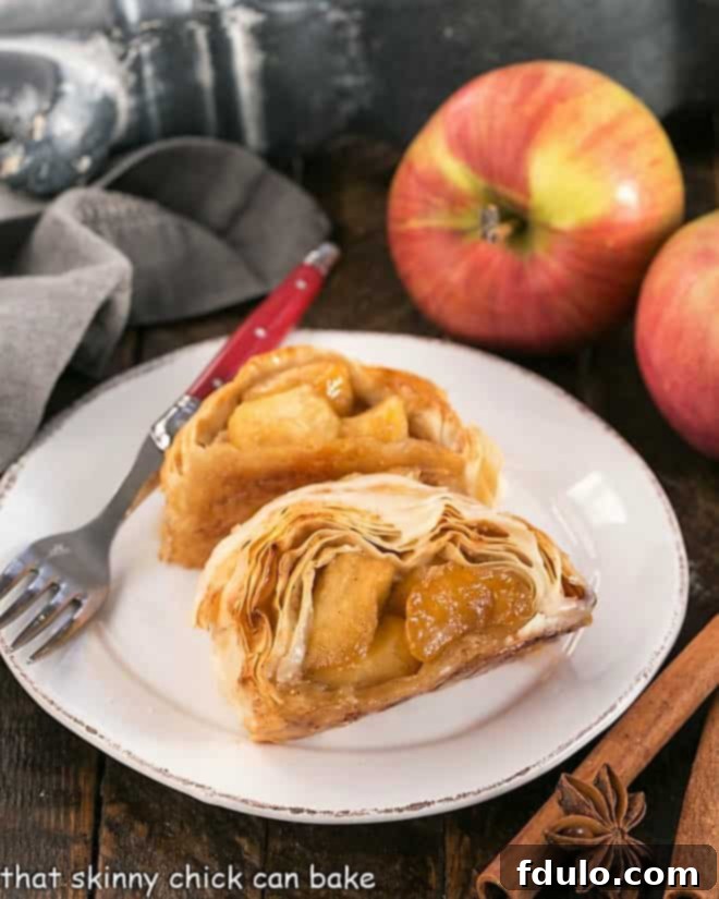 Homemade Apple Strudel is flaky, delicious and filled with sweet, cinnamon-spiced apples Two slices of strudel on a round white plate, showcasing the flaky crust and apple filling.