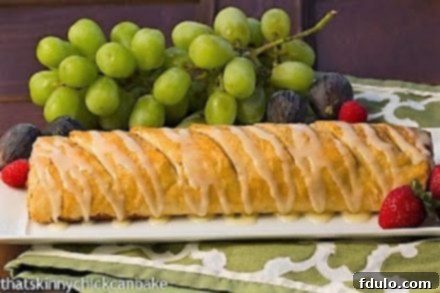 Apple strudel recipe made with packaged phyllo for an easy delicious dessert Apple Strudel with a delicate white chocolate drizzle, presented on a long white platter, ready to be served.
