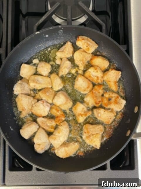 Step 2: Golden-brown chicken pieces sizzling in a hot skillet, perfectly cooked through.
