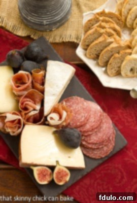 An overhead shot showcasing a lavish meat and cheese tray presented alongside a basket of freshly baked artisan bread.