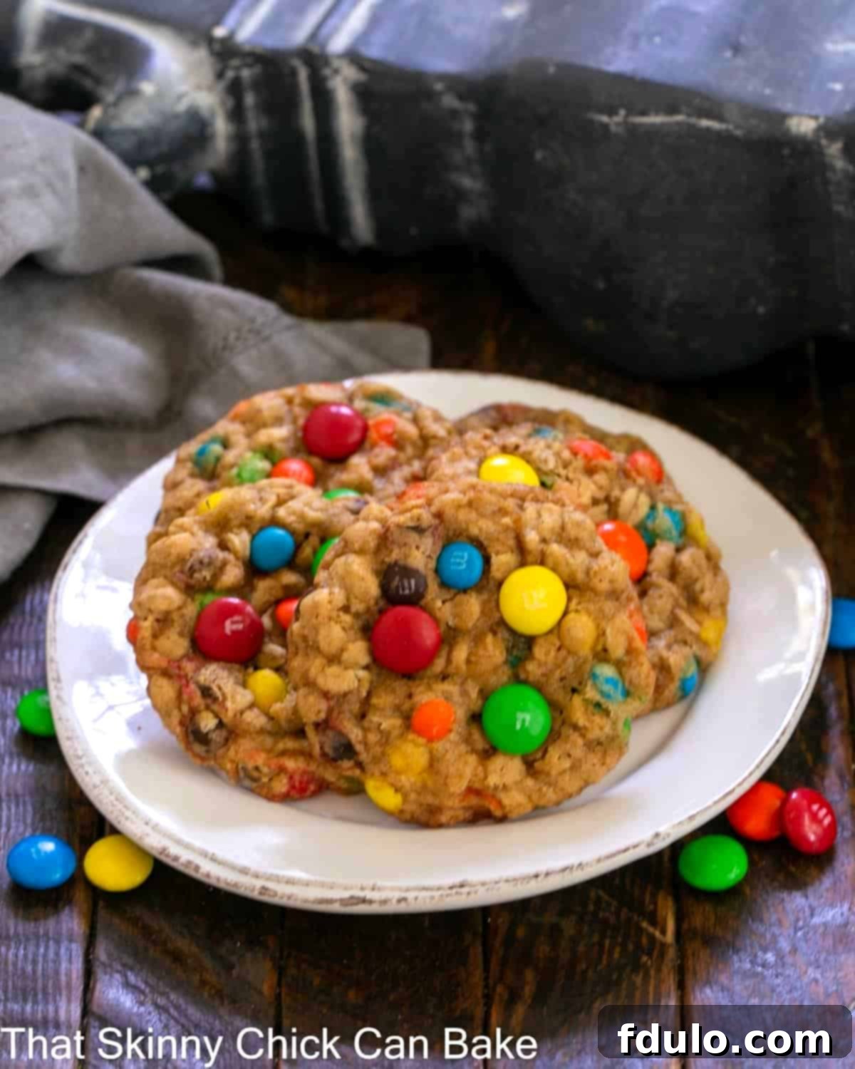 4 M & M cookies on a round white plate.