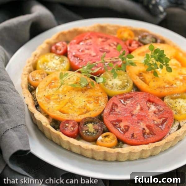 Fresh Tomato Tart on a white serving plate, garnished with basil