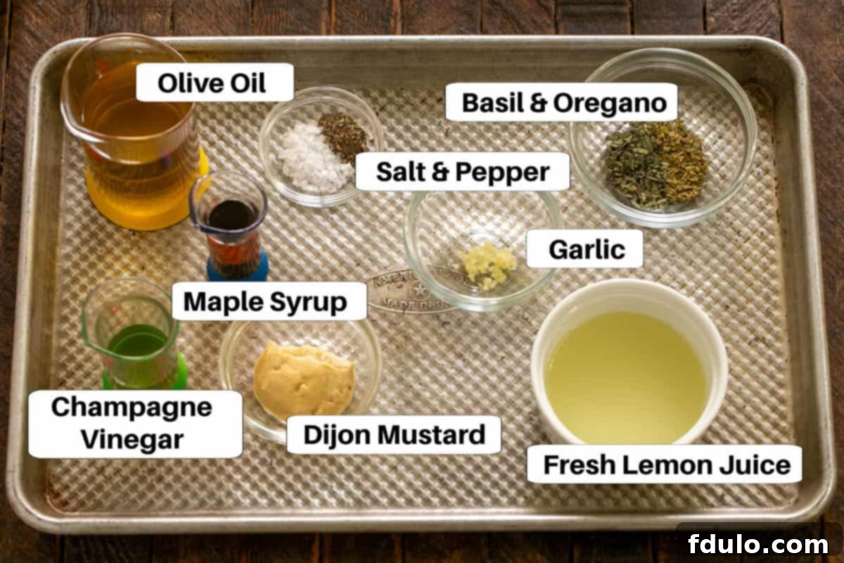 Ingredients for the Champagne Vinaigrette dressing displayed on a sheet pan, including olive oil, vinegar, lemon, and herbs.