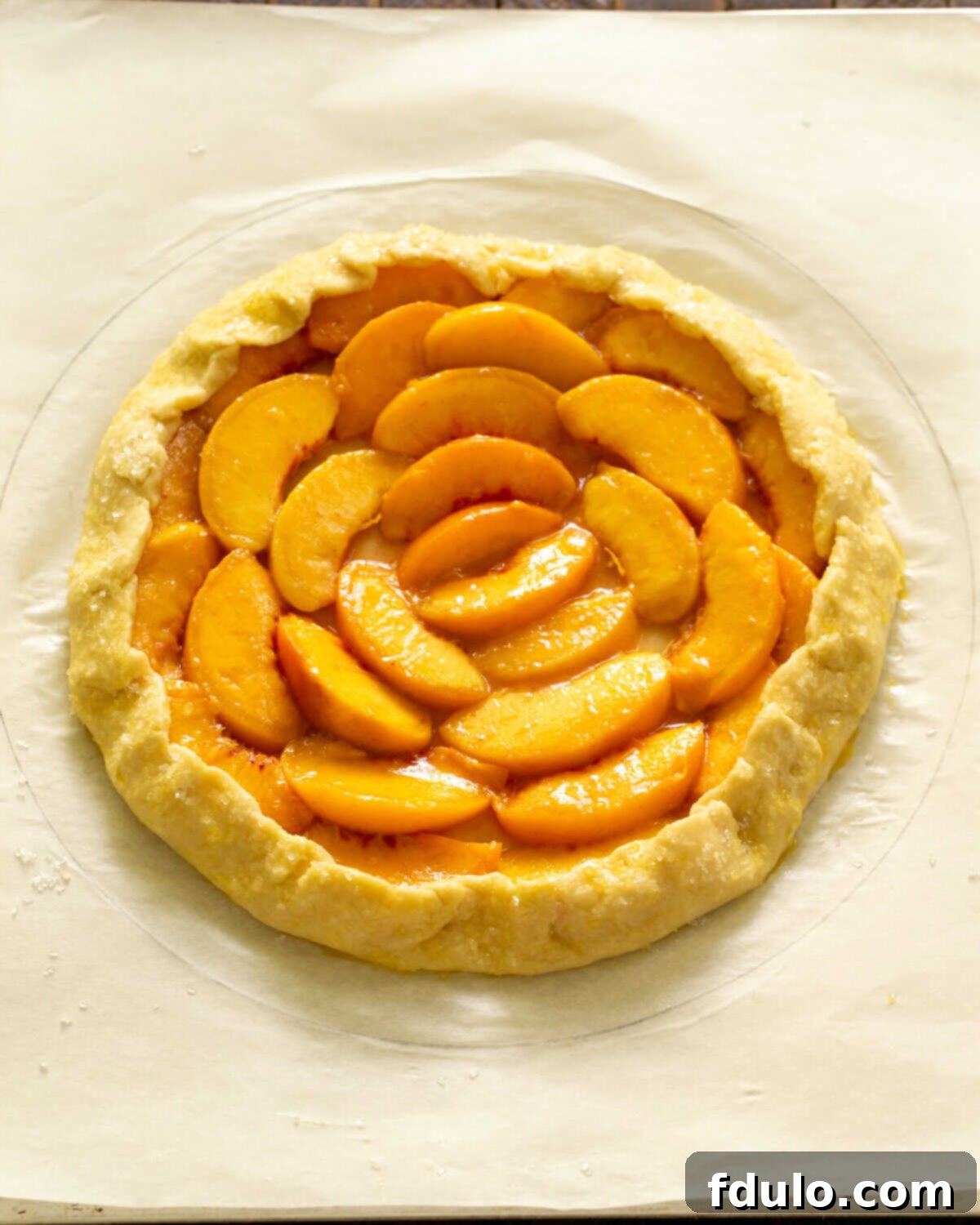 Step 6: Folding up the edges of the dough over the peaches, pleating as necessary to contain the juices.