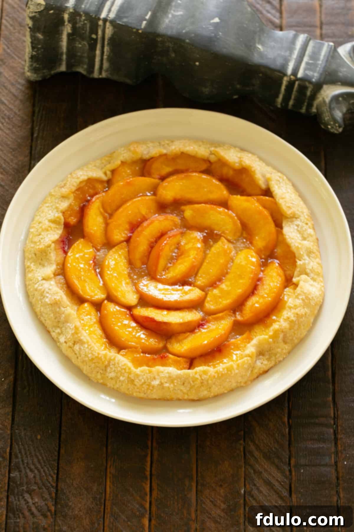 Step 7: Brushing the folded dough edge with an egg wash and sprinkling with coarse sugar.
