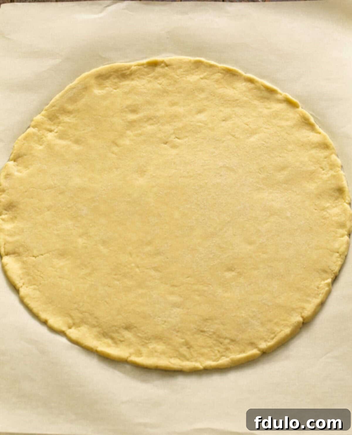 Step 3: Rolling out the chilled crust into a 12-inch round on parchment paper.