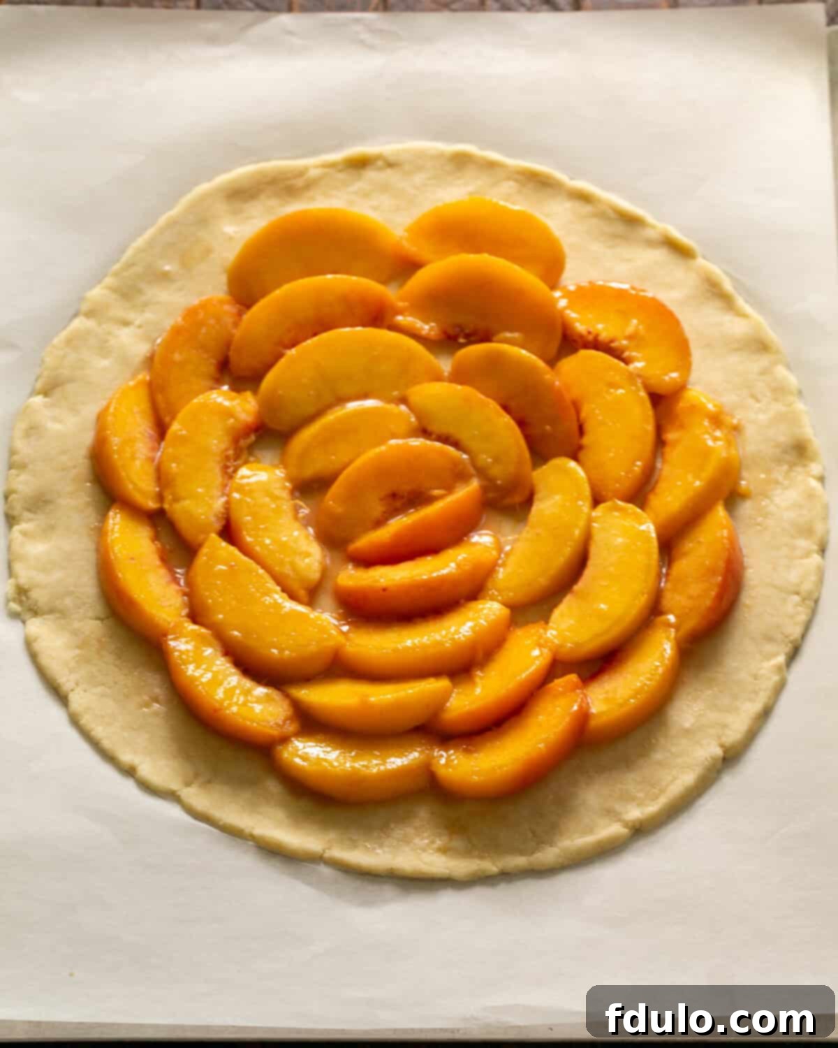 Step 5: Arranging peach slices in concentric circles in the center of the dough, leaving a clear border.