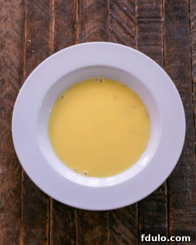 Bowl of egg mixed with milk, ready for dipping.
