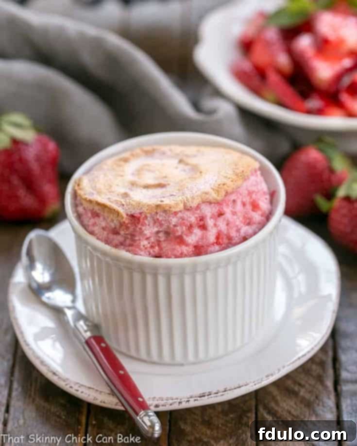 Beautifully baked strawberry soufflés with fresh berries as garnish.