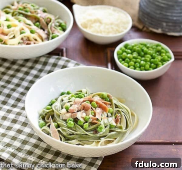 A close-up shot of Straw and Hay Pasta in a white bowl, resting on a green and white checkered napkin, highlighting its fresh ingredients.