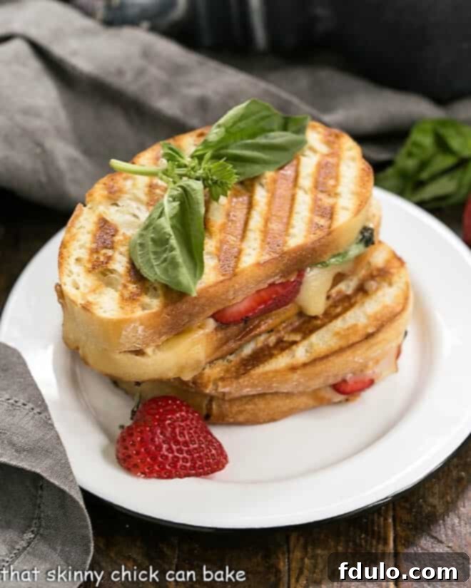 Creamy Brie Melt 2 A perfectly golden-brown Strawberry, Turkey, and Brie Grilled Cheese sandwich on a white lunch plate, with a hint of melted Brie oozing out.