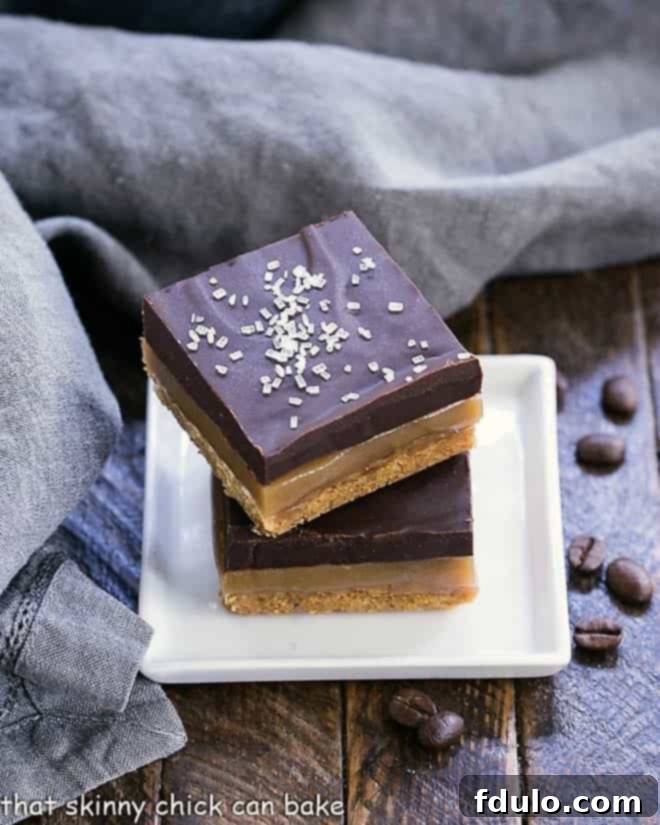 With a graham cracker crust, homemade caramel and an espresso or mocha ganache, these bars will make you swoon!! Caramel espresso bars stacked on a small square white plate.