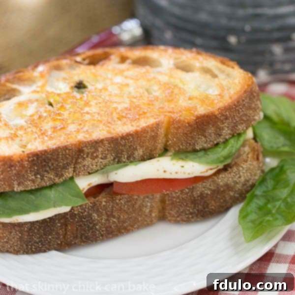 A delicious Caprese Grilled Cheese sandwich, featuring melty mozzarella, fresh tomatoes, and vibrant pesto, perfect for a summer lunch.
