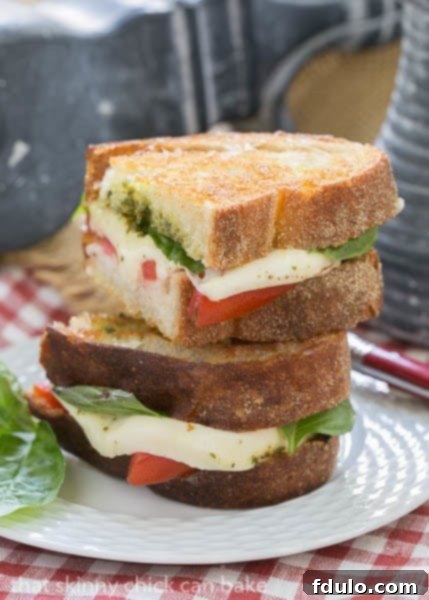 Close-up shot of a Caprese Grilled Cheese, showcasing the perfectly toasted bread and vibrant layers inside.