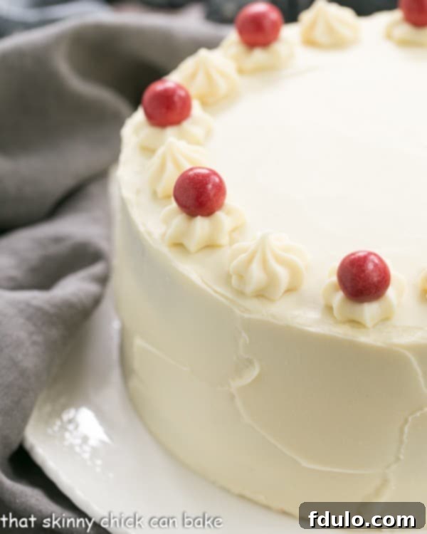 A stunning close-up of the Red Velvet Cake with White Chocolate Cream Cheese Frosting, presented on an elegant white cake plate.