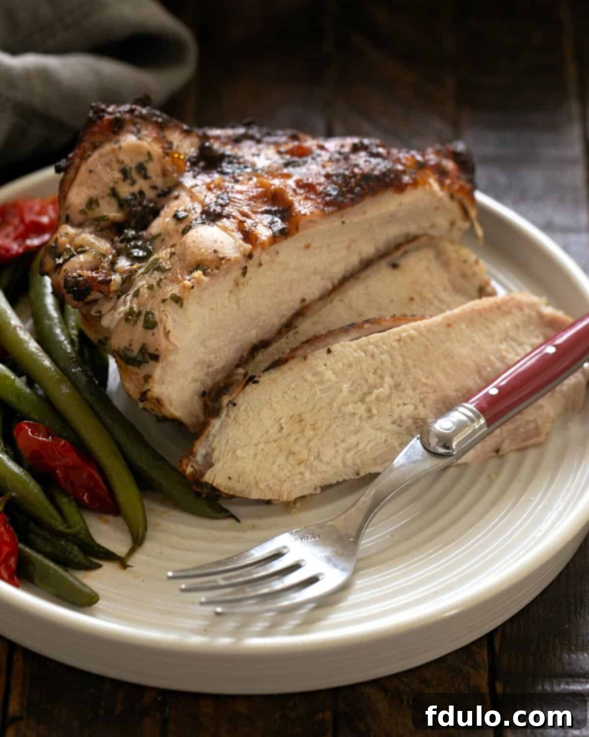 Beautifully grilled chicken piccata on a platter, garnished with fresh herbs and lemon slices.