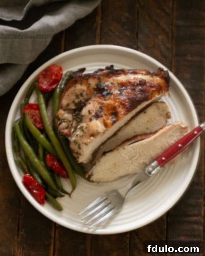 Easy Chicken Piccata Recipe served on a dinner plate with a fork and green beans.