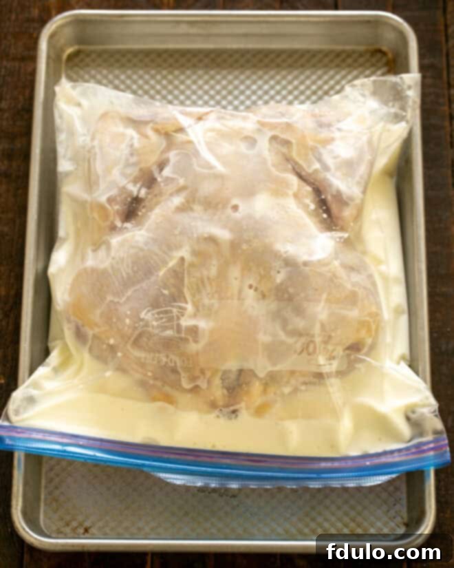 Buttermilk and whole chicken in a Ziploc bag.