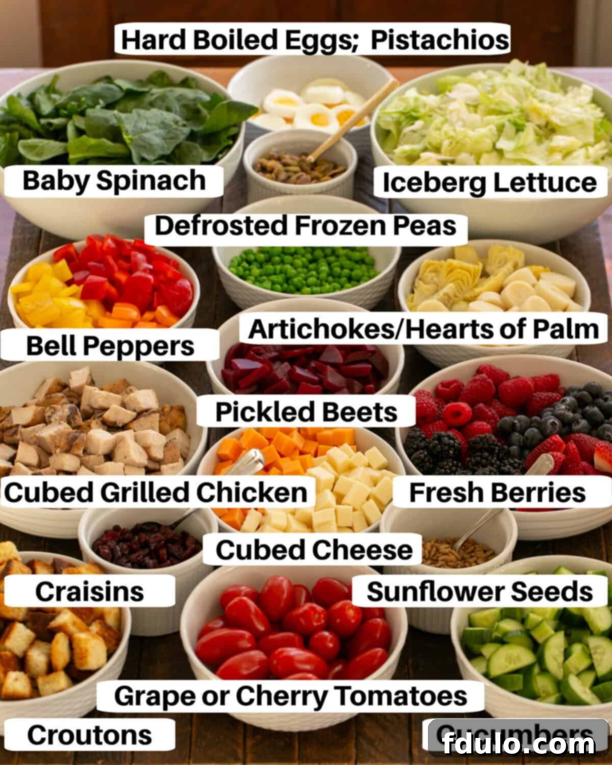 Salad bar ingredients in white bowls with labels.