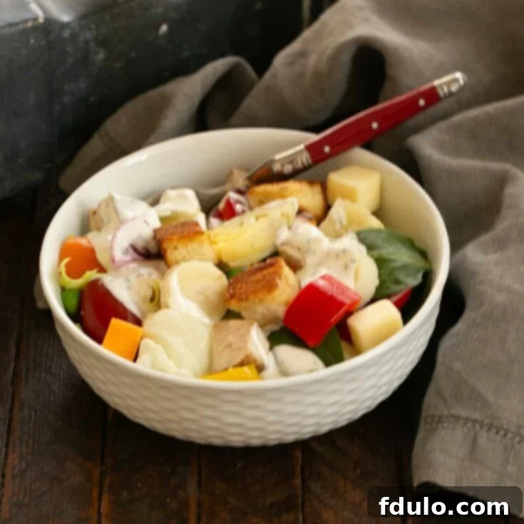 Salad Bar at home salad in a white bowl with a red handled fork.