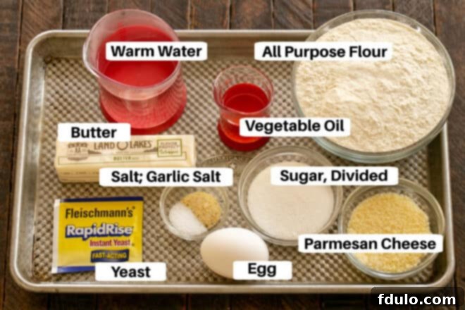 Carefully arranged ingredients for homemade breadsticks on a sheet pan, ready for preparation.