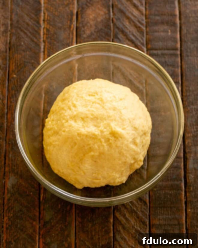 Dough being kneaded on a floured surface, demonstrating elasticity.