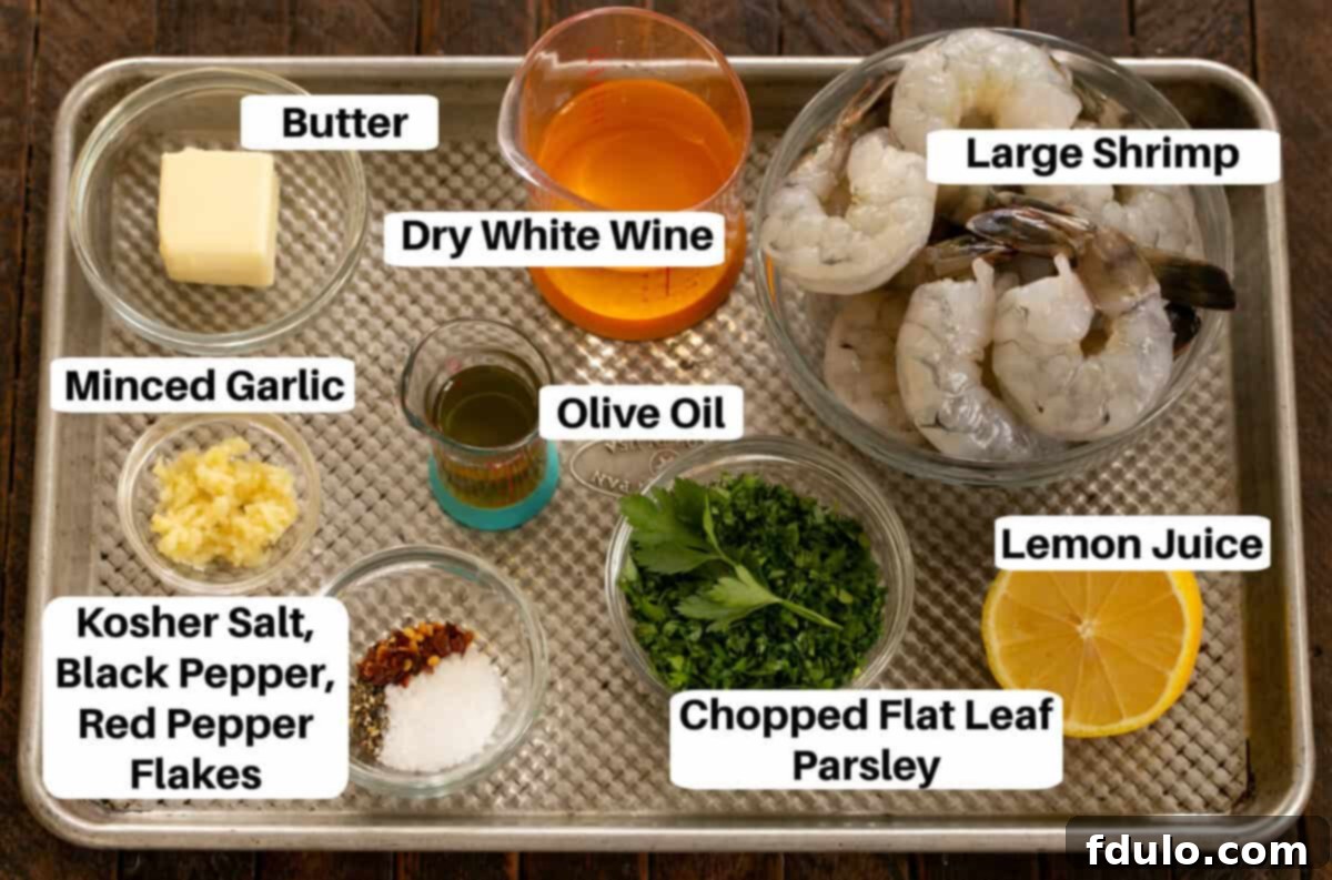 A sheet pan displaying all the fresh ingredients needed for Shrimp Scampi, clearly labeled for easy identification.