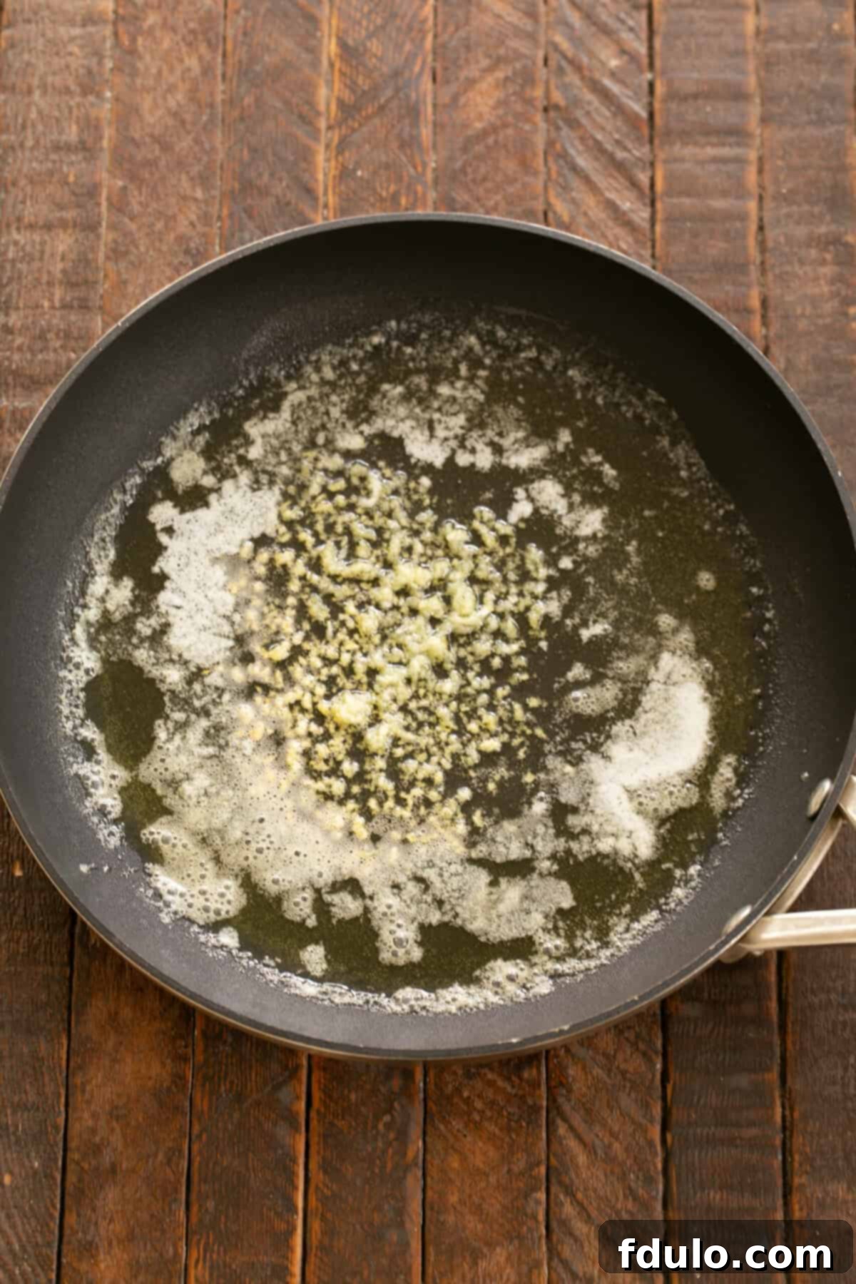 Butter and Olive oil gently heating together in a large skillet, forming the flavor base for the scampi.