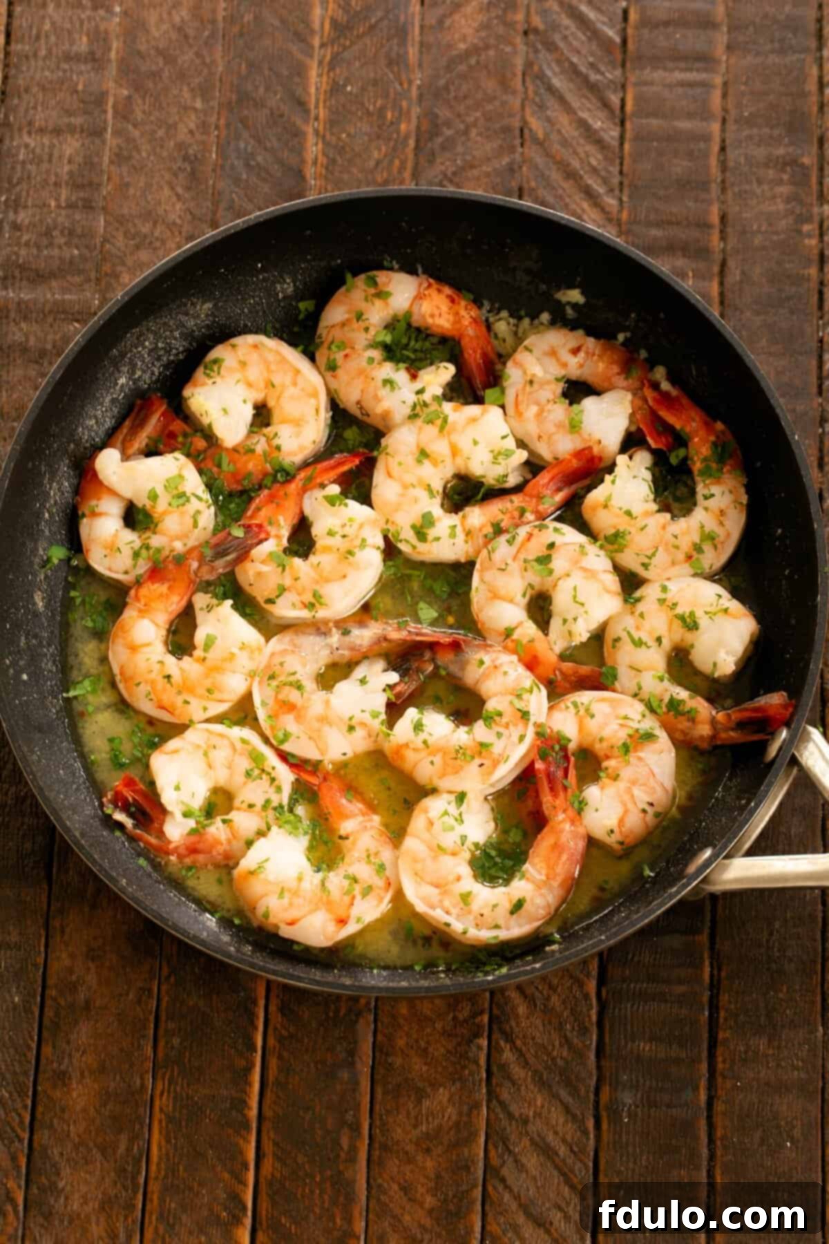 The finished Shrimp Scampi, garnished with fresh parsley and a squeeze of lemon, ready to be served immediately.