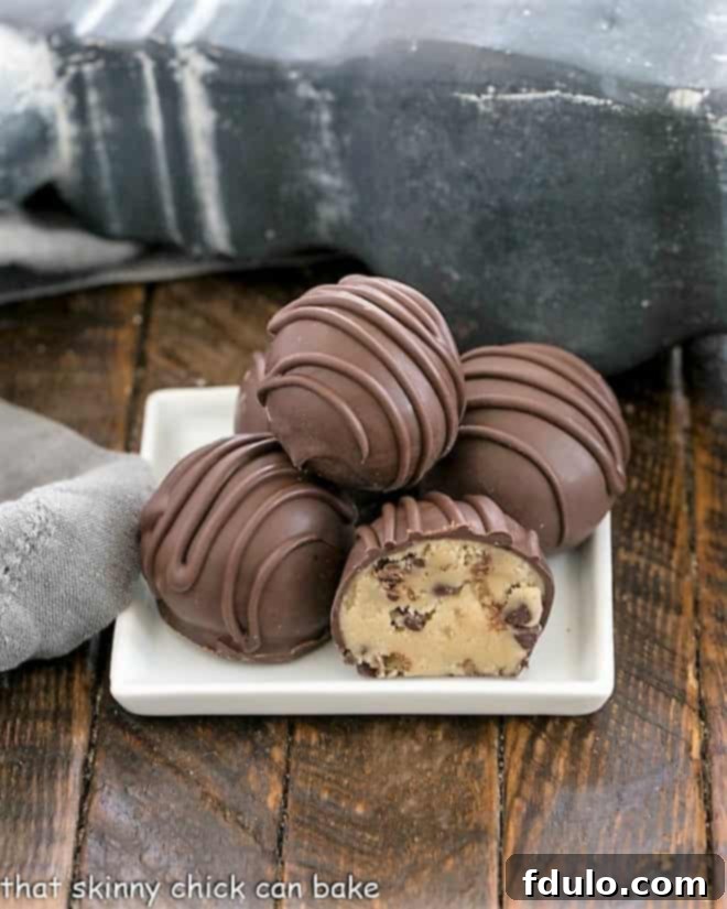 A stack of beautifully coated Cookie Dough Truffles on a pristine square white plate, ready to be enjoyed