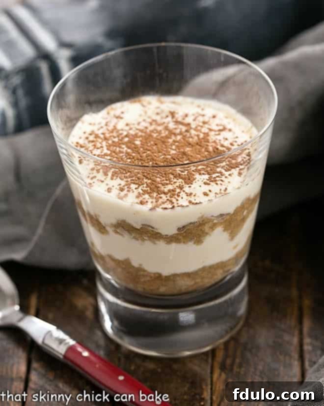Tiramisu Parfait in a glass with a red handled spoon.